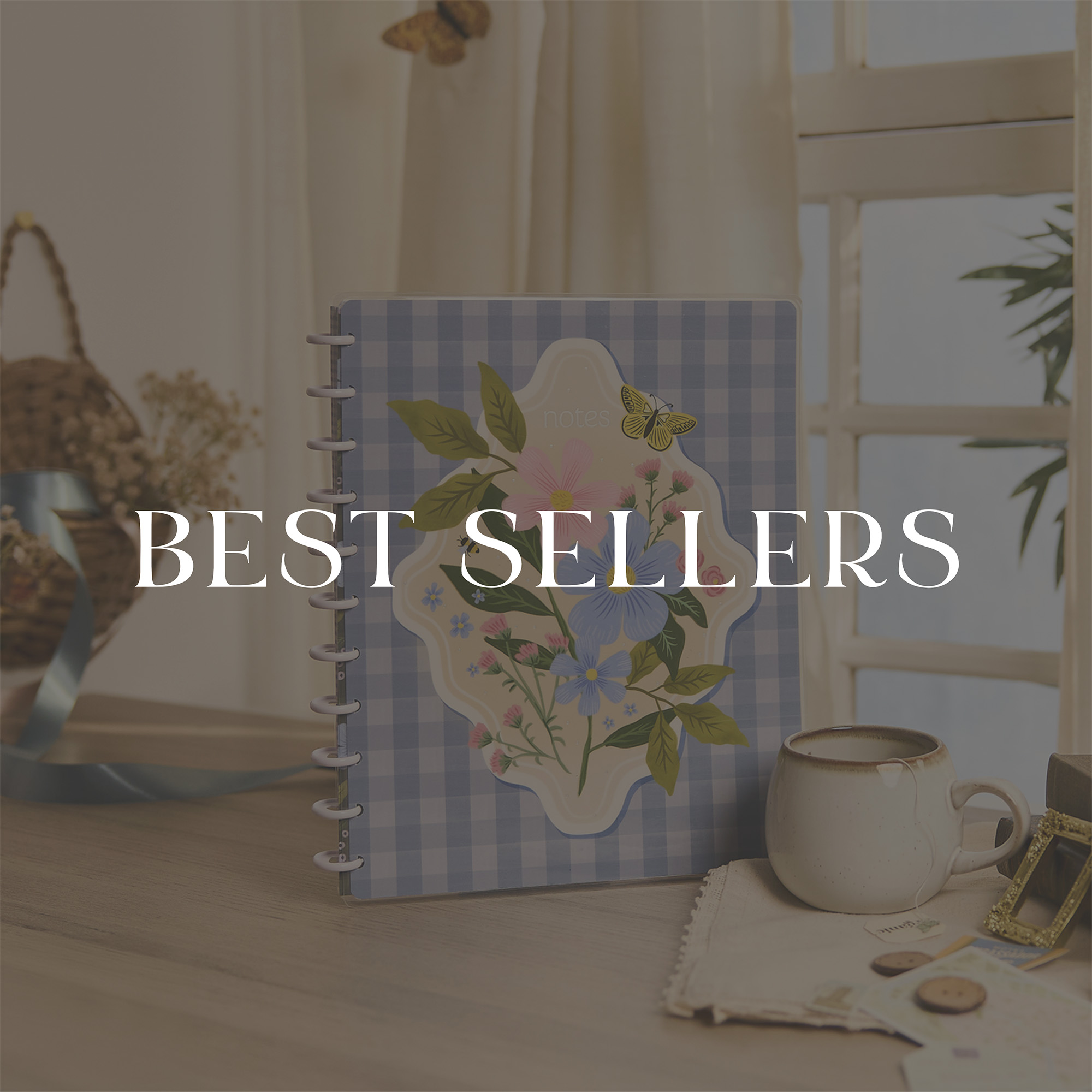 ```html
<img src="image.jpg" alt="Decorative notebook with floral design on a table, next to a cup. Text overlay reads 'Best Sellers'." />
```