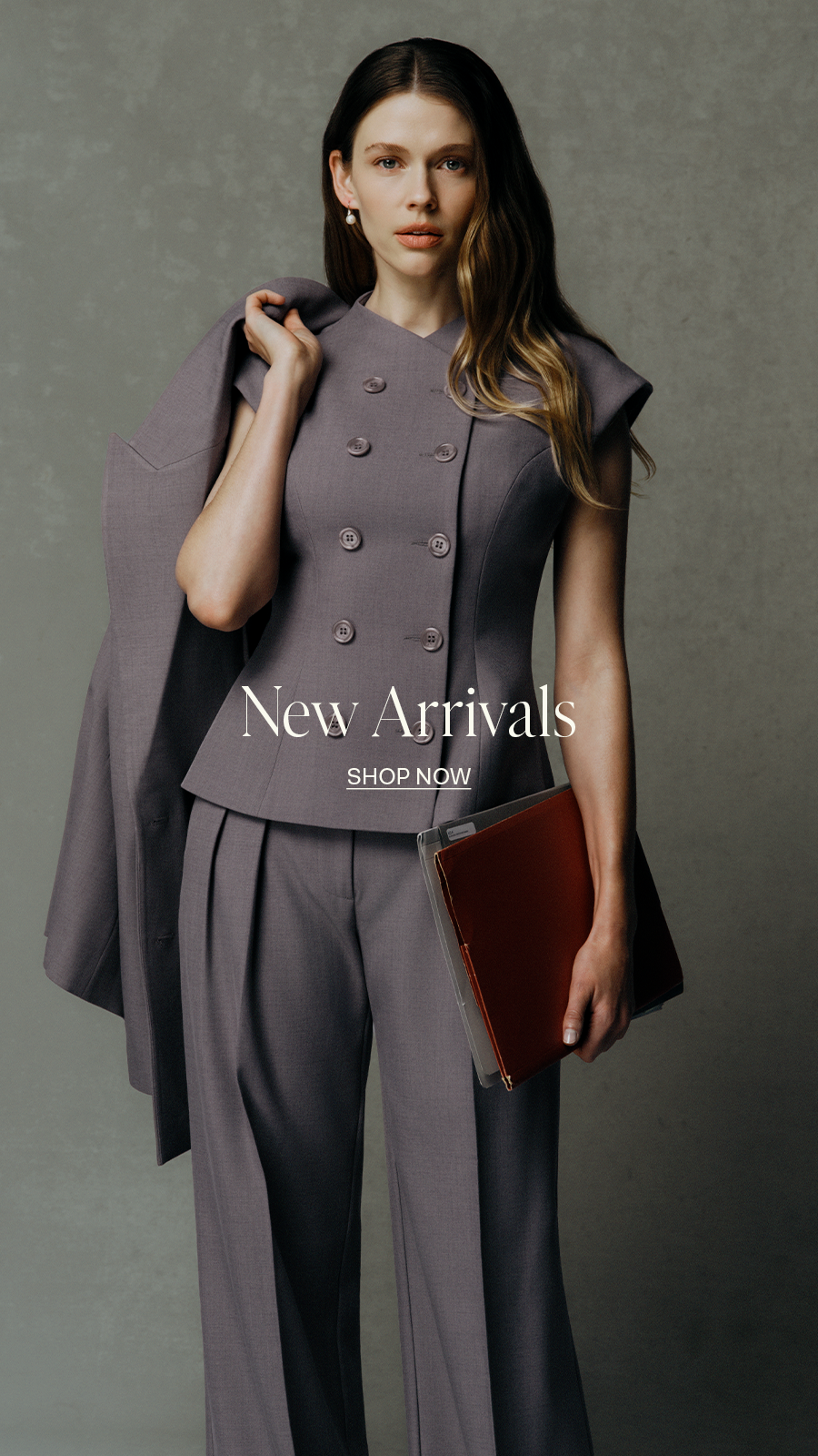 Female model wearing a grey double-breasted suit, holding a jacket and red clutch, with "New Arrivals" text overlay