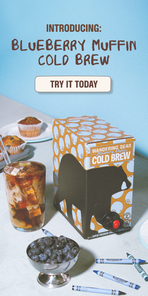 Wandering Bear Blueberry Muffin Cold Brew box beside an iced coffee glass, fresh blueberries, muffins, and Crayola crayons on a table.