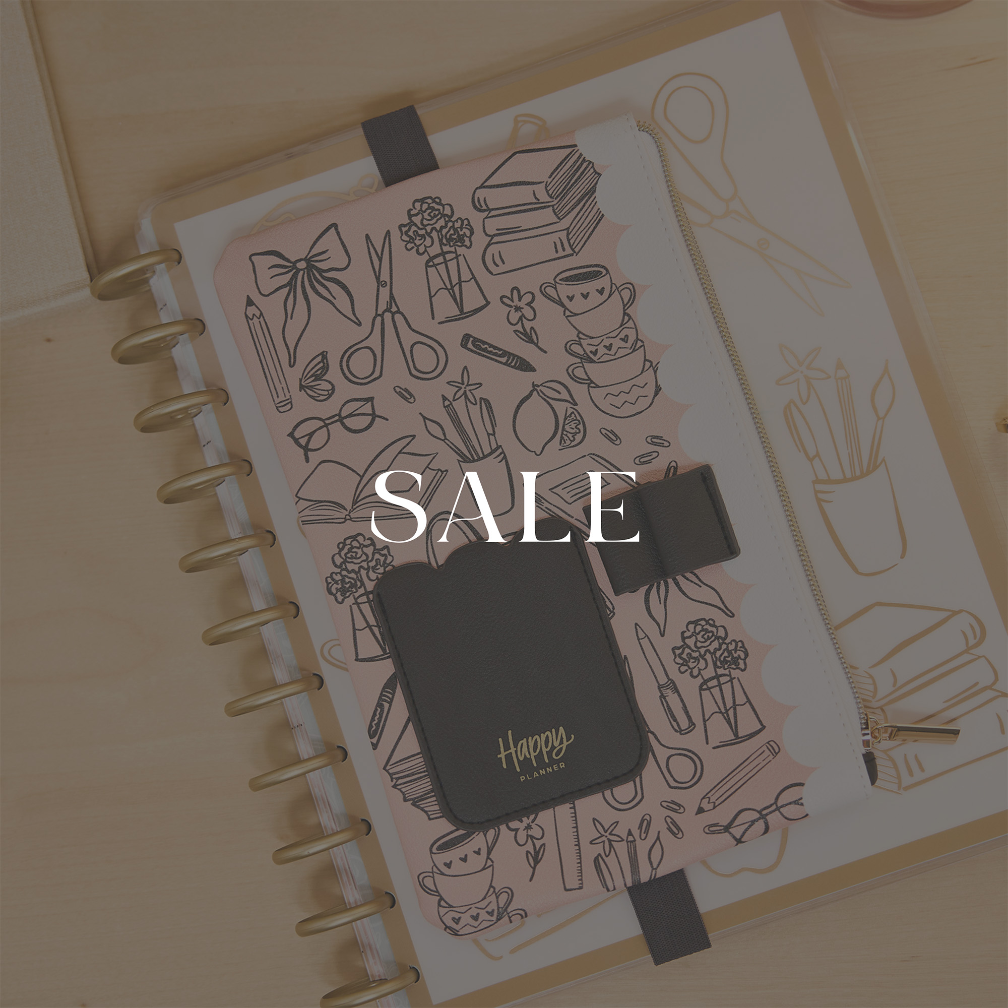 Happy Planner spiral notebook with illustrated cover and black accessory pouch, overlaid with "SALE" text