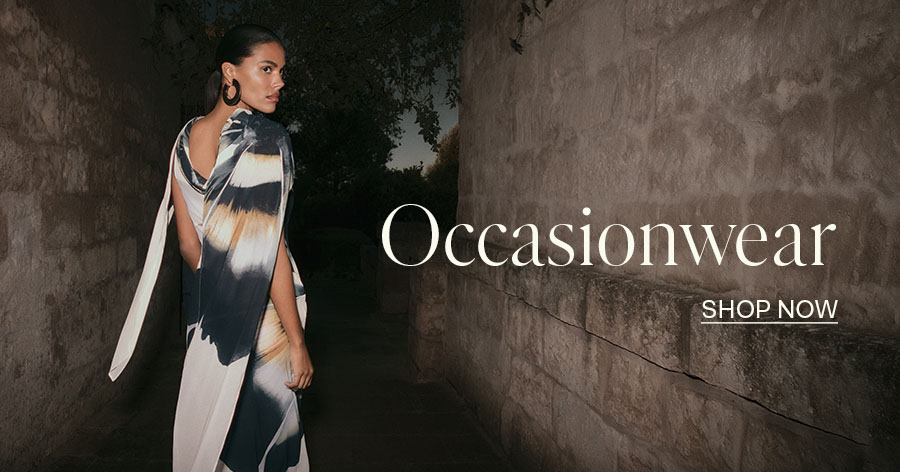 Woman in elegant tie-dye occasionwear dress posing outdoors with "Occasionwear - Shop Now" text overlay