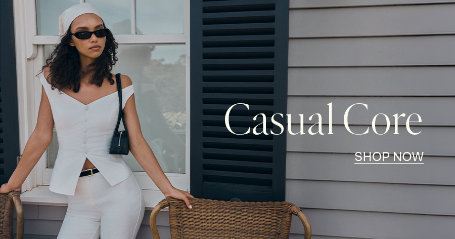 ```html
<img src="image.png" alt="Person in white clothing leaning on wicker chairs, text reads 'Casual Core - Shop Now'" />
```