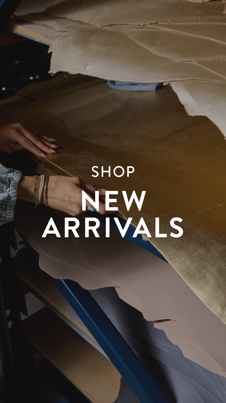 Hands organizing a stack of leather pieces in various shades on a shelf with the text "Shop New Arrivals" overlayed.