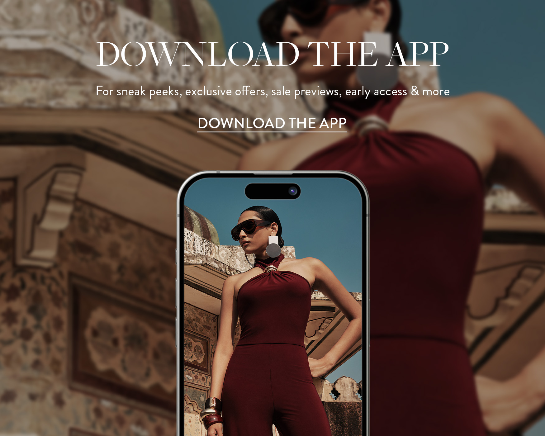```html
<img src="image.jpg" alt="Person wearing a maroon halter jumpsuit, posing with hands on hips. A smartphone screen displays the same image. Text reads 'Download the App' and offers sneak peeks, exclusive offers, and more." />
```