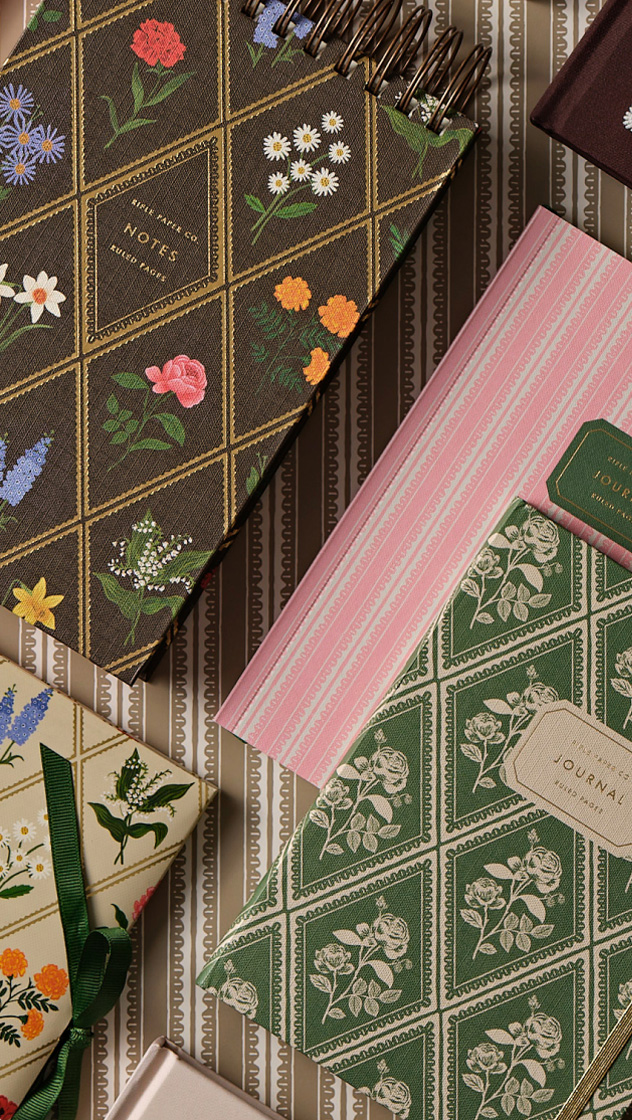 Rifle Paper Co. floral notebooks and journals with botanical patterns in brown, pink, and green covers