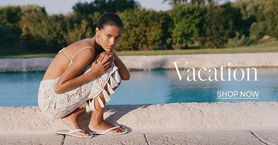 Woman in white crochet dress and flip-flops crouching by a pool, vacation fashion advertisement with "Shop Now" text