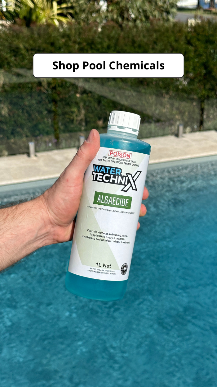 A hand holds a bottle of Water Technix Algaecide near a swimming pool. The label indicates it controls algae in pools.