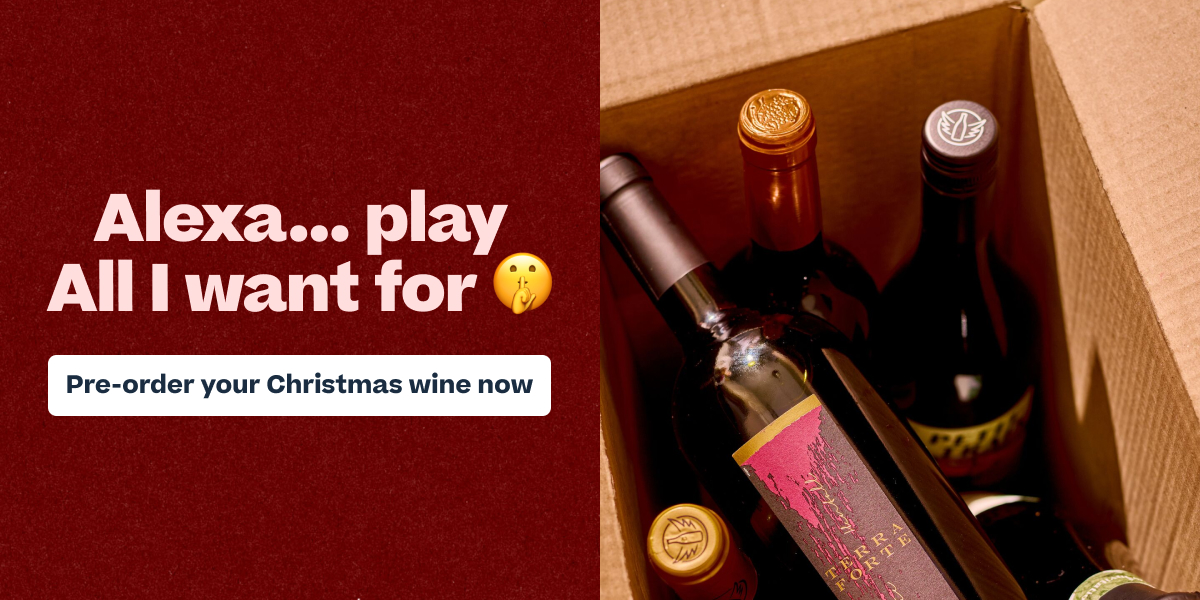 Christmas wine pre-order advertisement showing multiple wine bottles in a cardboard box with festive text and call-to-action button