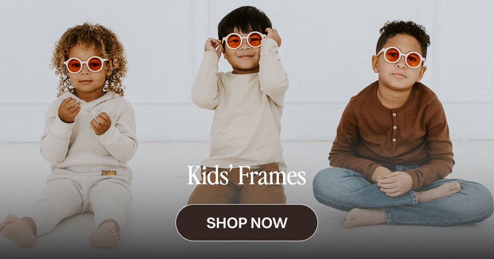 Three children wearing round white-framed sunglasses with orange lenses, promoting a "Kids' Frames" collection with a "Shop Now" button.